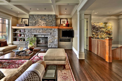 Living room - mid-sized traditional open concept dark wood floor living room idea in Seattle with beige walls, a standard fireplace, a stone fireplace and a wall-mounted tv