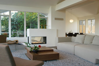 Minimalist open concept dark wood floor living room photo in Seattle with white walls and a two-sided fireplace