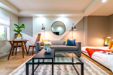 На фото: открытая гостиная комната среднего размера в стиле модернизм с отдельно стоящим телевизором, разноцветными стенами и светлым паркетным полом без камина