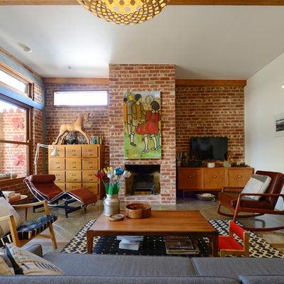 Example of a mid-century modern living room design in Adelaide with a brick fireplace