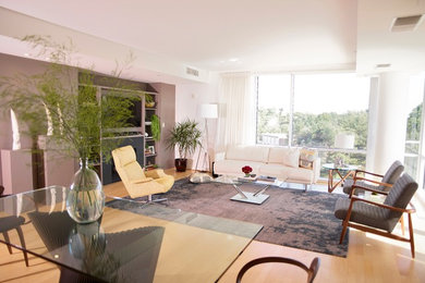Idée de décoration pour un grand salon minimaliste ouvert avec un mur beige, parquet clair, une cheminée standard, un manteau de cheminée en métal et un téléviseur encastré.