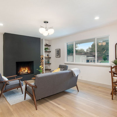Living room - mid-sized 1950s open concept light wood floor and beige floor living room idea in Denver with white walls, a standard fireplace, a plaster fireplace and no tv