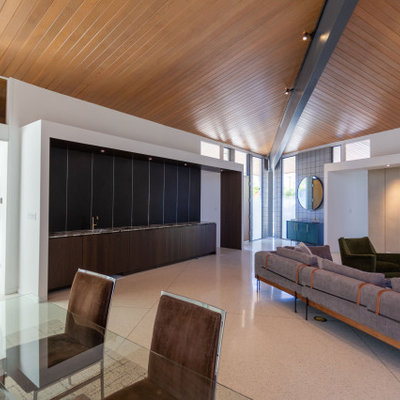 Living room - large mid-century modern open concept white floor and vaulted ceiling living room idea in Other with a bar, white walls, a standard fireplace, a metal fireplace and a wall-mounted tv