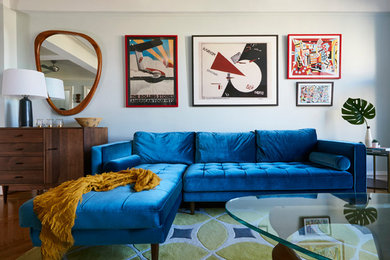 ニューヨークにある高級な中くらいなミッドセンチュリースタイルのおしゃれな独立型リビング (青い壁、無垢フローリング、茶色い床、据え置き型テレビ) の写真