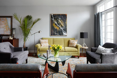 Modelo de salón abierto clásico renovado con paredes grises y suelo de madera en tonos medios