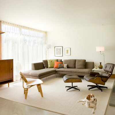 Mid-sized trendy open concept concrete floor and gray floor living room photo in Boston with white walls, a stone fireplace and a concealed tv
