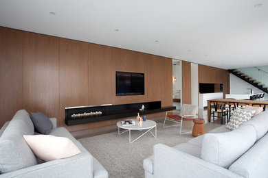 Modern inredning av ett stort vardagsrum, med bruna väggar, betonggolv och en inbyggd mediavägg