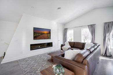 Idée de décoration pour un salon design ouvert avec un mur blanc, parquet clair et un sol gris.