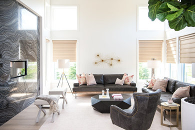 Cette image montre un salon design avec un mur blanc, un sol en bois brun, un sol marron et canapé noir.