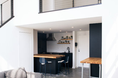Example of a small trendy loft-style concrete floor and gray floor living room design in San Francisco with white walls