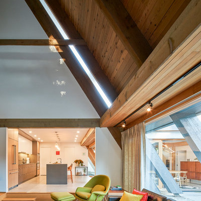 Large 1950s open concept light wood floor and brown floor living room photo in Vancouver with white walls, a standard fireplace, a plaster fireplace and a wall-mounted tv