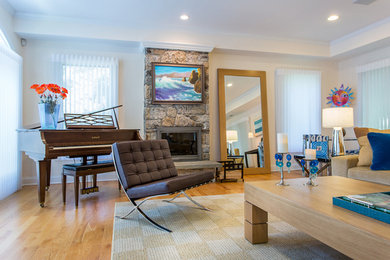 This is an example of a large modern open plan living room in New York with a home bar, beige walls, light hardwood flooring, a standard fireplace, a stone fireplace surround and a wall mounted tv.