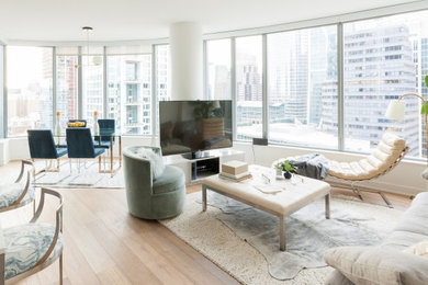 Idéer för ett modernt vardagsrum, med vita väggar, ljust trägolv, en fristående TV och beiget golv