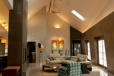 Imagen de salón abierto actual grande con paredes blancas, chimenea de doble cara, marco de chimenea de metal y suelo beige