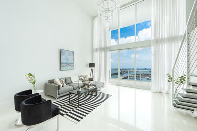 Example of a large trendy open concept white floor living room design in Miami with white walls and no tv