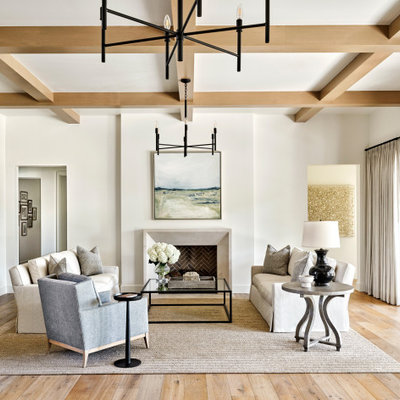 Example of a large transitional formal and open concept light wood floor, beige floor and coffered ceiling living room design in Phoenix with white walls, a standard fireplace, a plaster fireplace and no tv