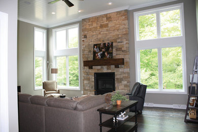Example of an arts and crafts open concept dark wood floor living room design in Other with gray walls