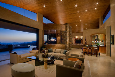 Expansive modern open plan living room in Phoenix with beige walls, limestone flooring, a standard fireplace, a stone fireplace surround and a home bar.