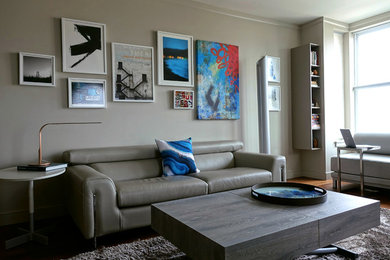 Стильный дизайн: маленькая изолированная гостиная комната в современном стиле с серыми стенами, паркетным полом среднего тона, мультимедийным центром и коричневым полом для на участке и в саду - последний тренд
