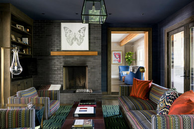 Идея дизайна: изолированная гостиная комната в стиле неоклассика (современная классика) с синими стенами, стандартным камином, телевизором на стене и фасадом камина из кирпича