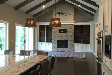 Imagen de salón abierto de estilo de casa de campo con paredes grises, suelo de madera en tonos medios, marco de chimenea de piedra y suelo marrón