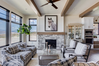 This is an example of a rural formal open plan living room in Salt Lake City with beige walls, a standard fireplace, a stone fireplace surround, no tv and light hardwood flooring.
