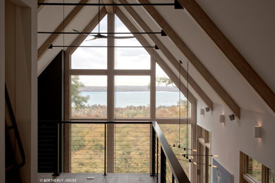 Diseño de salón tipo loft y abovedado nórdico extra grande con suelo de madera clara, chimenea de doble cara, marco de chimenea de metal y suelo gris