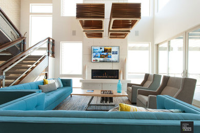 Example of a large trendy concrete floor living room design in Salt Lake City with white walls, a standard fireplace and a wall-mounted tv
