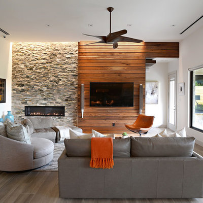 Example of a mid-sized trendy open concept medium tone wood floor and brown floor living room design in Dallas with white walls, a stone fireplace, a ribbon fireplace and a wall-mounted tv