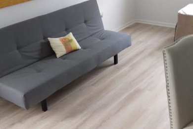 Idee per un soggiorno minimalista con pareti bianche e parquet chiaro