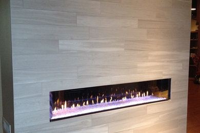 シアトルにあるコンテンポラリースタイルのおしゃれなリビング (横長型暖炉、タイルの暖炉まわり) の写真