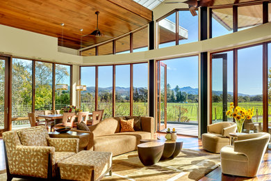 Large trendy open concept medium tone wood floor living room photo in San Francisco with beige walls and no fireplace