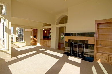 Example of a large minimalist open concept carpeted and beige floor living room design in Other with beige walls, a standard fireplace and a tile fireplace