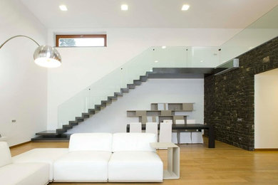 Ejemplo de salón abierto moderno de tamaño medio con paredes blancas y suelo de madera clara
