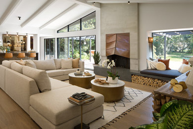 Inspiration for a 1960s open concept medium tone wood floor and brown floor living room remodel in San Diego with white walls and a standard fireplace