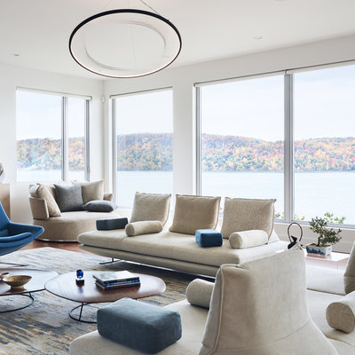 Example of a minimalist open concept medium tone wood floor and brown floor living room design in New York with white walls