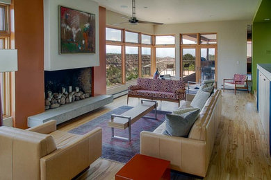 Foto de salón abierto minimalista grande con suelo de madera clara, todas las chimeneas y marco de chimenea de yeso