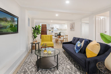 Small modern open plan living room in Brisbane with white walls, concrete flooring, no fireplace, a wall mounted tv and grey floors.