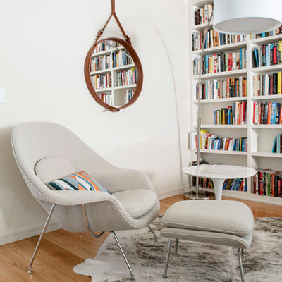 Trendy medium tone wood floor living room photo in Other with white walls