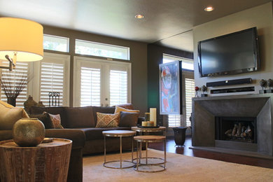 サンディエゴにあるお手頃価格の広いコンテンポラリースタイルのおしゃれなリビング (緑の壁、標準型暖炉、コンクリートの暖炉まわり、壁掛け型テレビ、コンクリートの床) の写真