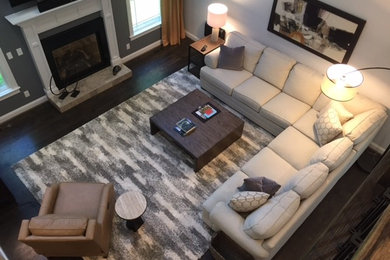 Exempel på ett stort klassiskt separat vardagsrum, med en fristående TV, grå väggar, mörkt trägolv, en standard öppen spis, brunt golv och en spiselkrans i sten