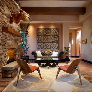 Example of a mid-sized trendy living room design in Phoenix with orange walls, a standard fireplace and a stone fireplace