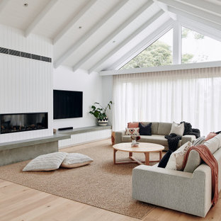 Foto di un grande soggiorno design aperto con pareti bianche, parquet chiaro, camino classico, cornice del camino in intonaco, TV a parete, pavimento beige, soffitto ribassato e pannellatura