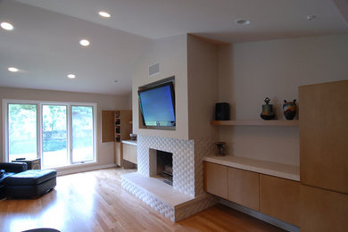 Bild på ett mellanstort funkis vardagsrum, med mellanmörkt trägolv, en standard öppen spis, en väggmonterad TV och brunt golv