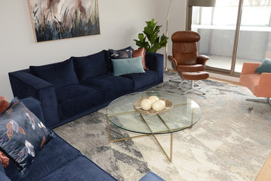 Foto de salón abierto actual de tamaño medio con paredes grises, suelo de madera clara y televisor independiente