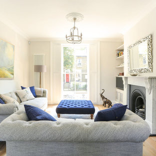 Photo of a classic living room in London with beige walls, medium hardwood flooring, a standard fireplace and brown floors.