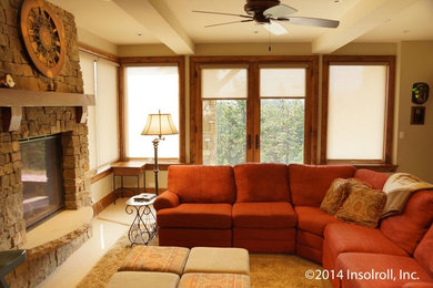 Example of a mid-sized mountain style enclosed medium tone wood floor living room design in Other with beige walls, a standard fireplace and a stone fireplace