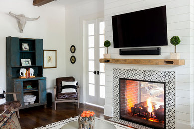 Inspiration for a mid-sized modern open concept medium tone wood floor and brown floor living room remodel in Charleston with white walls, a two-sided fireplace, a tile fireplace and a wall-mounted tv