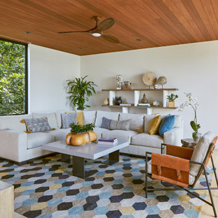 Immagine di un grande soggiorno stile rurale aperto con pareti beige, pavimento con piastrelle in ceramica, nessun camino, TV a parete, pavimento grigio e soffitto in legno