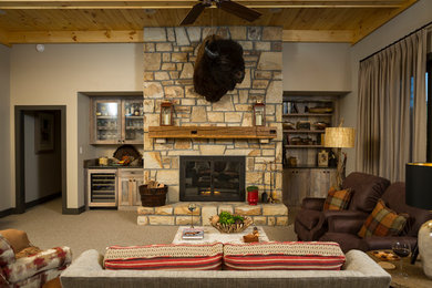 Photo of a large rustic open plan living room in Charlotte with beige walls, carpet, a standard fireplace, a stone fireplace surround, a home bar, no tv and grey floors.